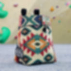 colourful apache patterned chalk bag sat in front of a climbing wall