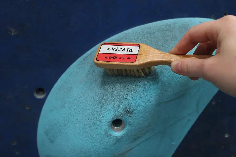 Thumbnail: Personalised name tag chalk brush is being used to clean a large blue sloper in the colchester climbing project