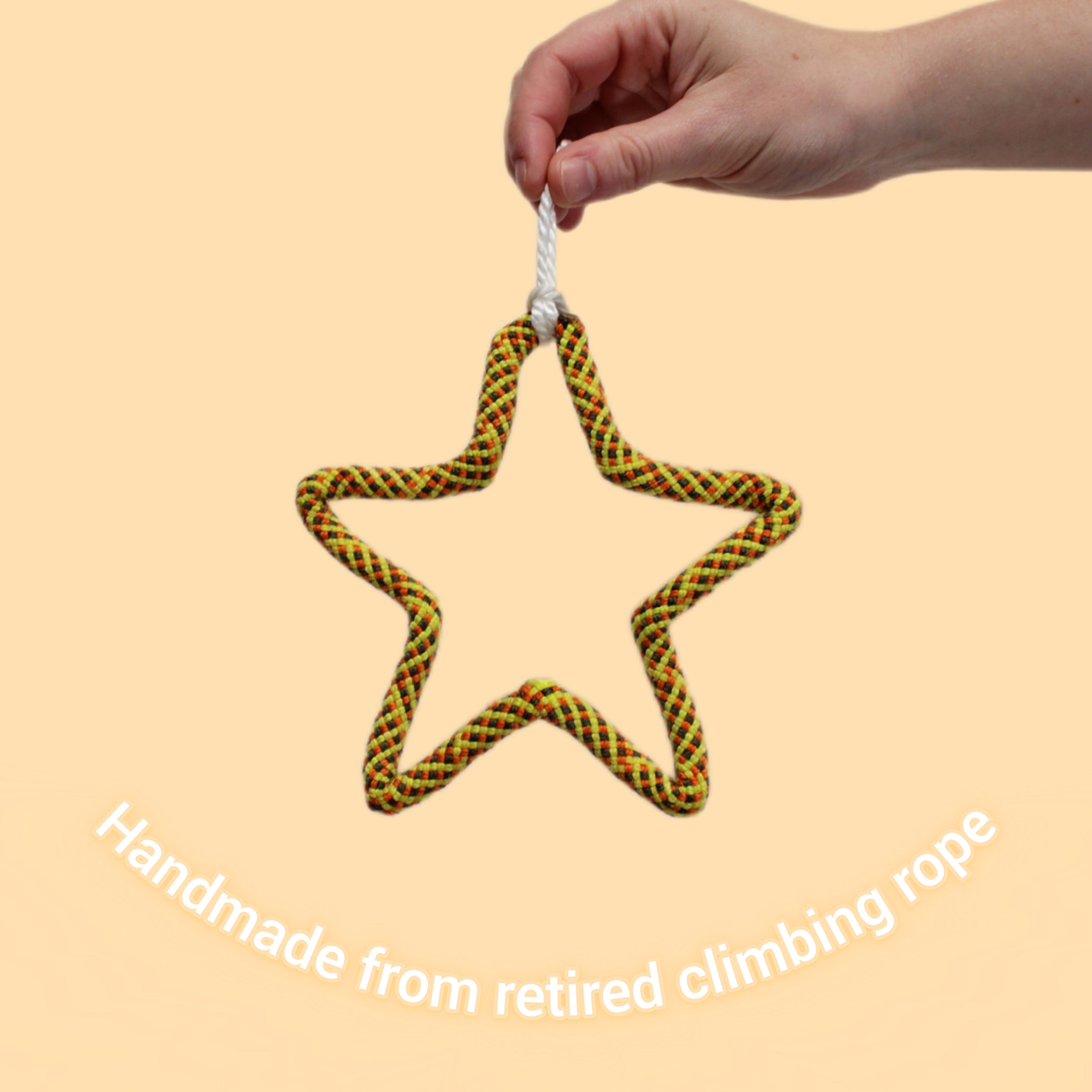 A climbing rope ornament in the shape of a star in yellow colours, handmade from repurposed climbing ropes