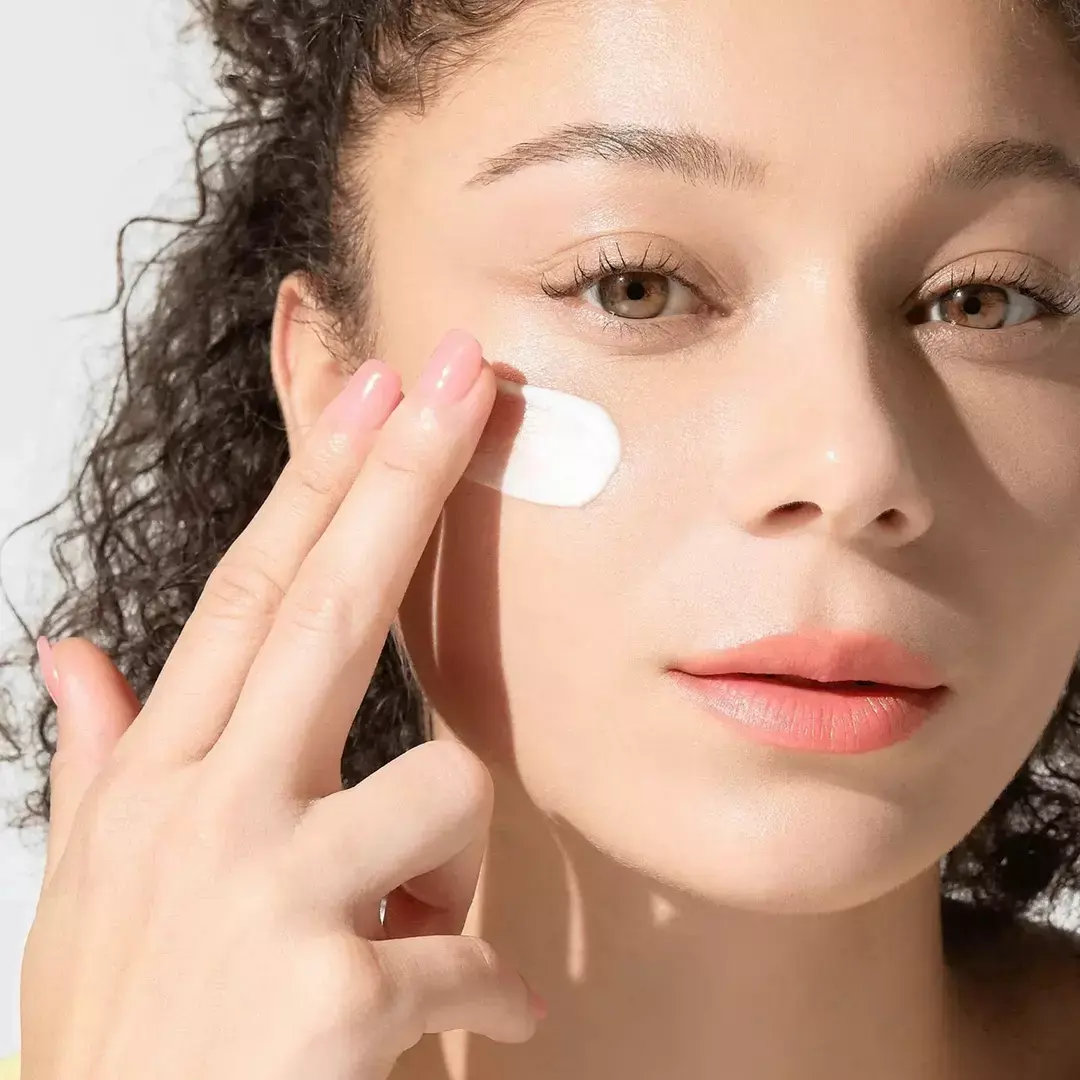 Modelo aplicando el protector solar calmante Anua Heartleaf Silky Moisture Sun Cream SPF50+ PA++++