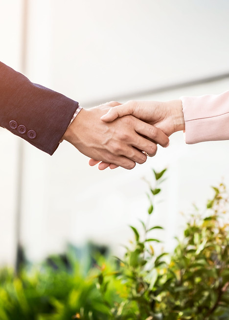 Business partners shaking hands to finalize a new supplier agreement in the precision manufacturing industry.