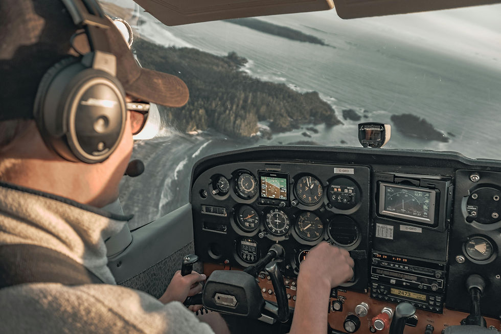 Pilot in cockpit with headset controls a small aircraft over a coastal landscape. Instrument panel visible. A clear sky sets a calm mood.