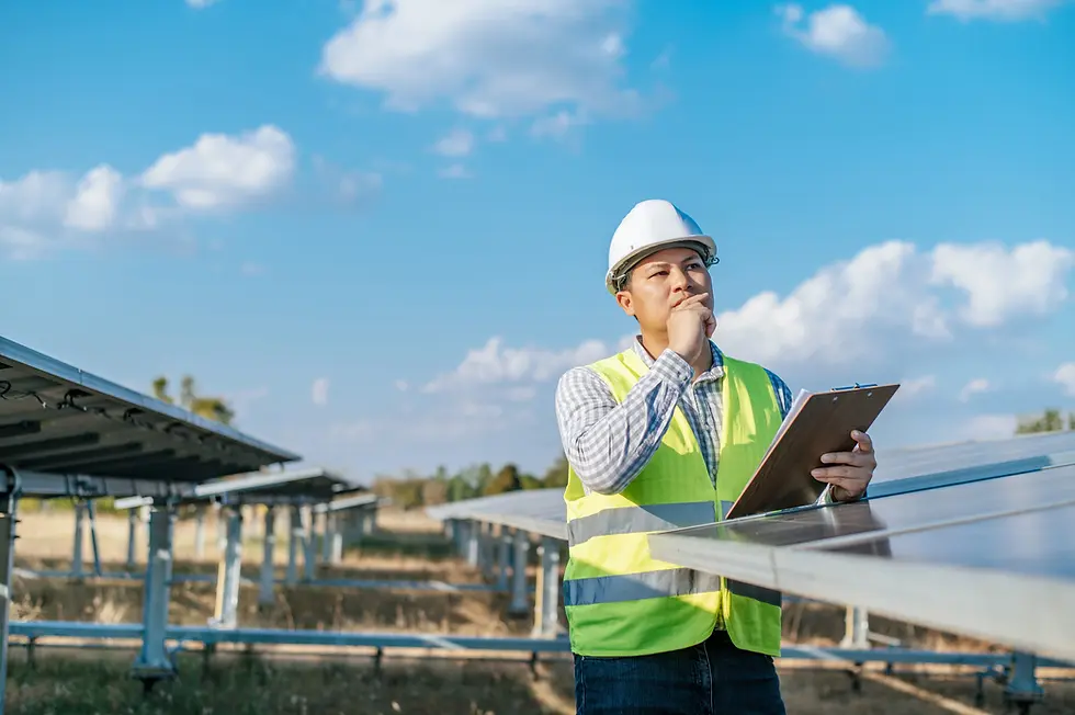 Engineer in hard hat inspecting solar farm