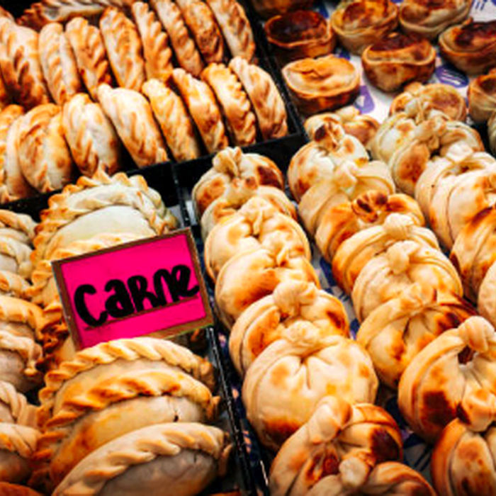 Rows of baked empanadas with a Carne label