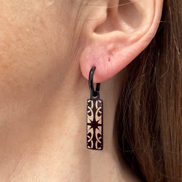 Double-sided 8mm x 24mm rectangular stainless steel drop earrings featuring the Celtic tiles shield design in a metallic finish. The slim double-sided drops show the artwork from either side and create a clean, contemporary look. by Urband London