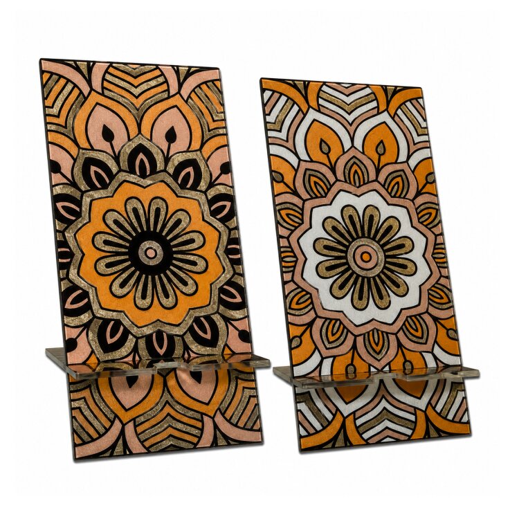 A double-sided stainless steel smartphone stand featuring the earthy mandala Ambience design in a metallic finish. The reversible artwork lets you display either side, while the cable recess makes it practical for charging while your phone is on the stand. Handmade in London. by Urband London