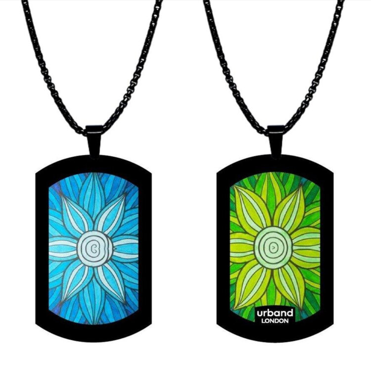 A double-sided 24mm x 40mm stainless steel pendant featuring the Flowers Daisies blossom design in a metallic finish. The artwork is visible on both sides, giving the pendant a distinctive look from every angle. Waterproof, scratch-resistant and nickel-free, it is handmade in London and presented in a gift box. by Urband London