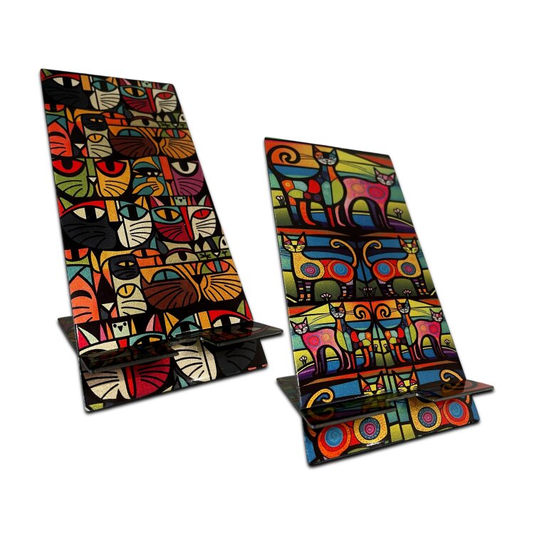 A double-sided stainless steel smartphone stand featuring the Art cats paradise design in a metallic finish. Made from two interlocking 1.5mm stainless steel pieces, with an 80 x 95mm base and an 80 x 170mm upright. The reversible artwork lets you display either side, while the cable recess makes it practical for charging while your phone is on the stand. Handmade in London. by Urband London