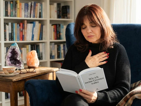 Eine Frau liest in einem Buch und hat die Hand auf dem Herzen