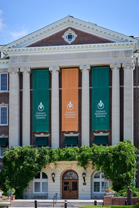 the front entrance to the main building at CIA with banners and topiary about the door