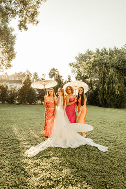 women standing in field with parasols