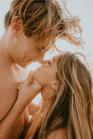 man grabbing womans chin to kiss her