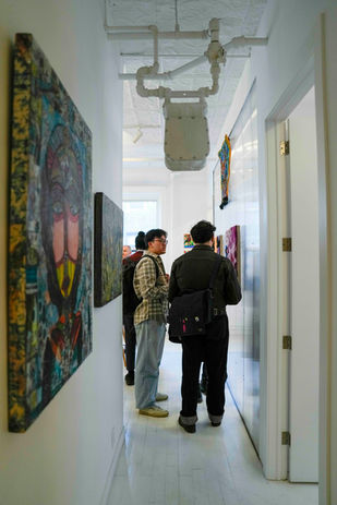 Visitors viewing contemporary artworks during Lower East Side gallery opening