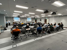 Professionals attending a modern conference room meeting with screen presentations.
