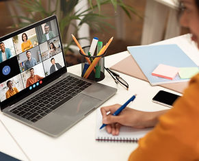 shutterstock_2476394263.jpg. Attorney participating in a virtual CLE workshop on a laptop with a diverse group of online att