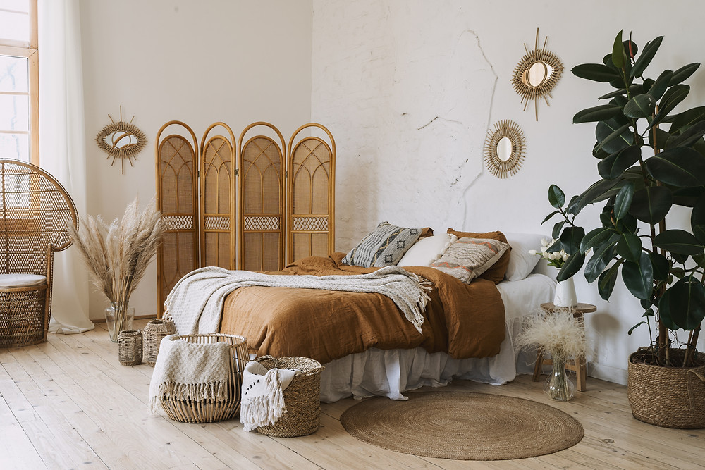 Quarto com objetos de decoração artesanal, cestos, biombo, espelhos com molduras na parede.