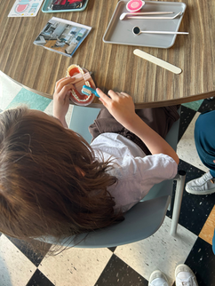 child practicing brushing teeth in a model of a mouth