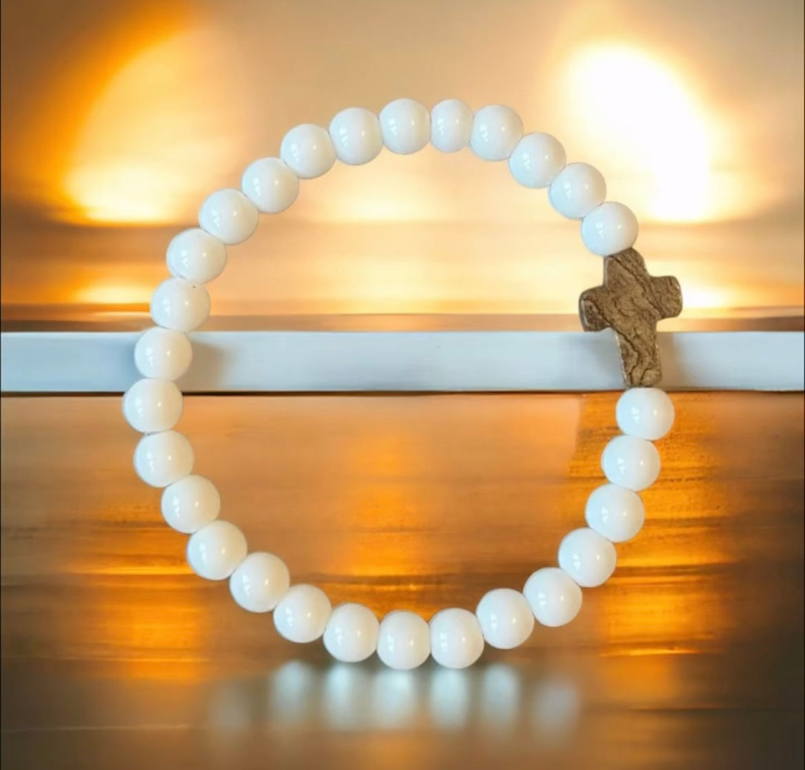 "Armband med vita pärlor och brunt stenkors"