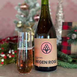 Bottle of sparkling rosé styled with holiday greenery and decor