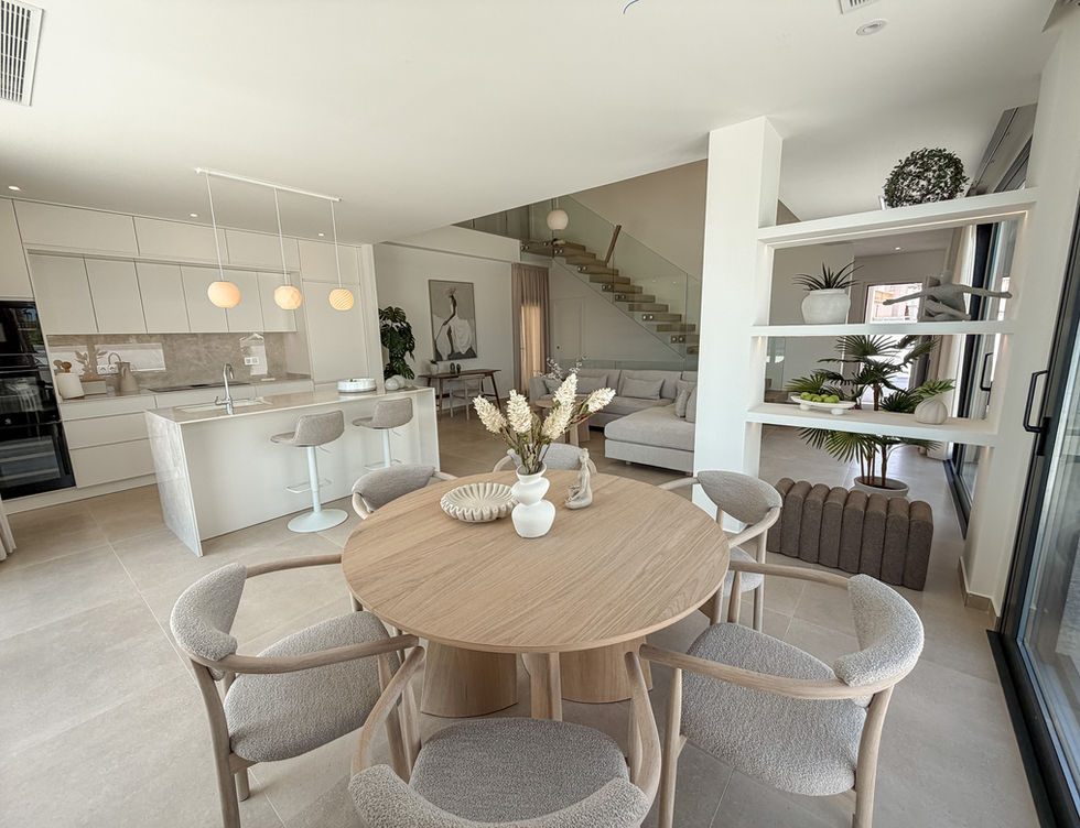 Open-plan kitchen and dining area with modern interior and staircase view