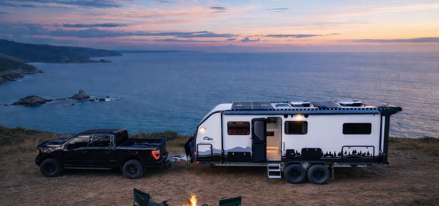 An Offroad Grit RV set up on a clifftop above the ocean at dusk