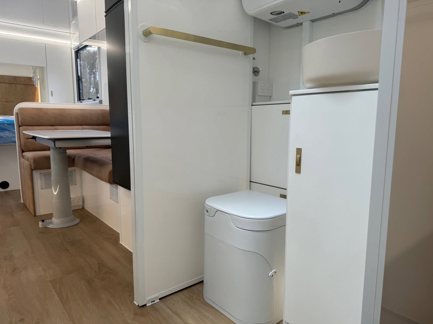 OGO composting toilet beside the vanity, with the dinette beyond