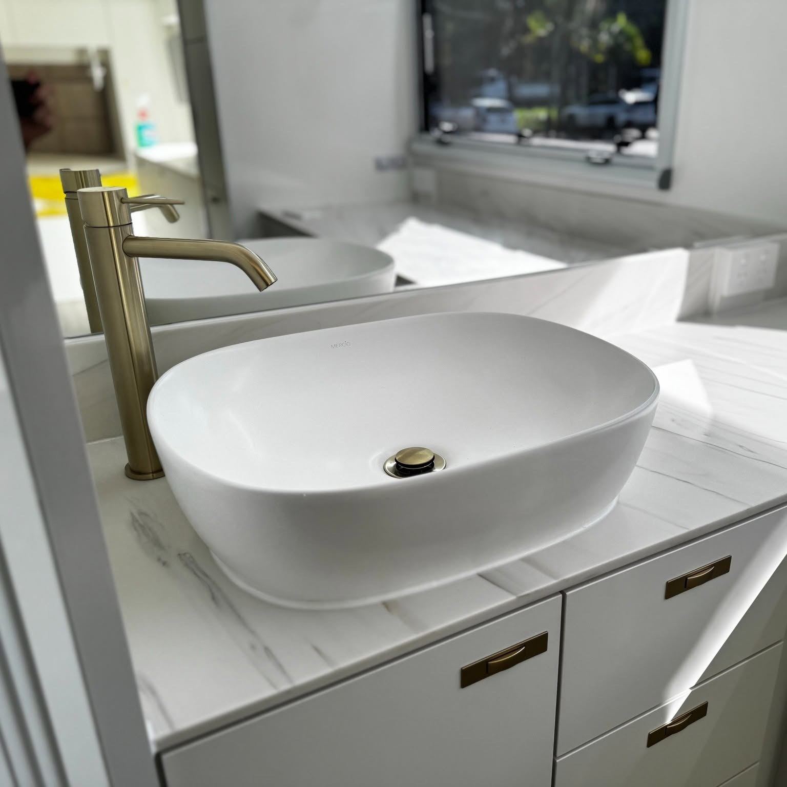 Gold tapware over a vessel basin