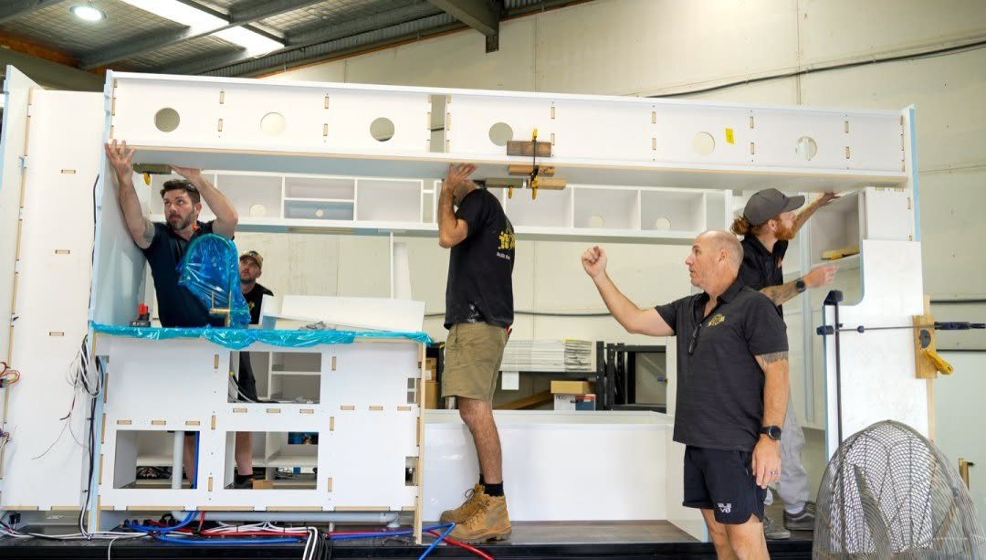 The team lifting overhead cabinetry into a van
