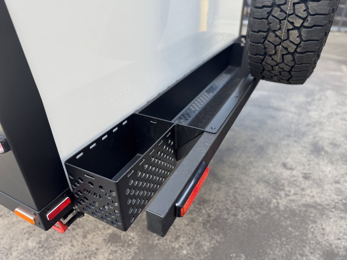 The rear bumper with a perforated wood box and the spare wheel