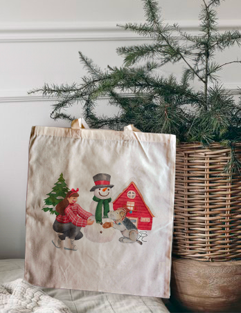 Woman building a snowman with a fox terrier Christmas tote bag