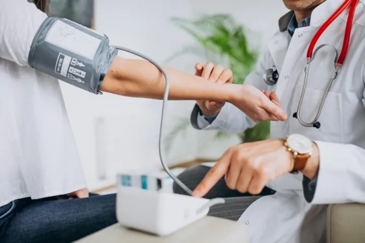 young-male-psysician-with-patient-measuring-blood-pressure