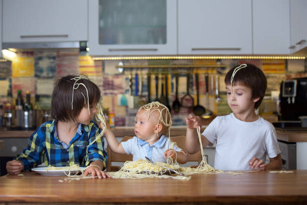 Children sitting down together eating dinner before a telemarketer ruins the evening