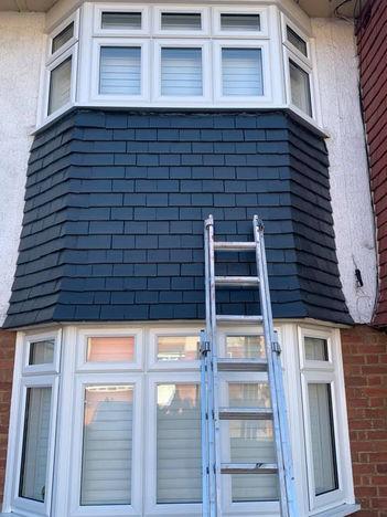 Freshly painted exterior tiles on a bay window feature, showcasing a durable and polished finish.