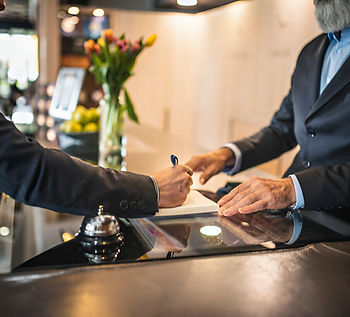 Young Businessman Checking Into Hotel and Signing Guest Book.jpg
