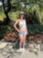 Picture of Annie outside at the huntington botanical gardens in a white crop top, bucket hat, and shorts