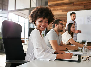 Portrait of happy young african woman sitting at a business presentation with colleagues i