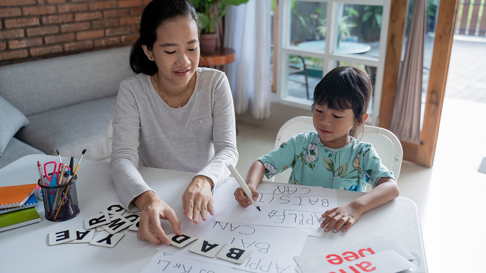 A woman and child at a table doing a word activity with flashcards.