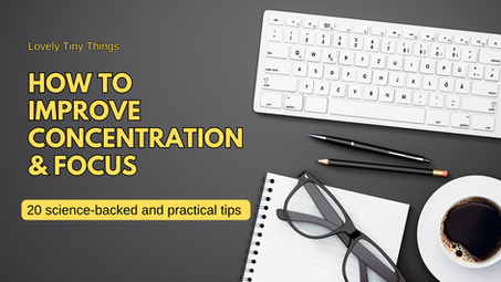 Keyboard, glasses, notebook, pencils, and coffee cup on a gray desk. Text: "How to Improve Concentration & Focus. 20 science-backed tips."