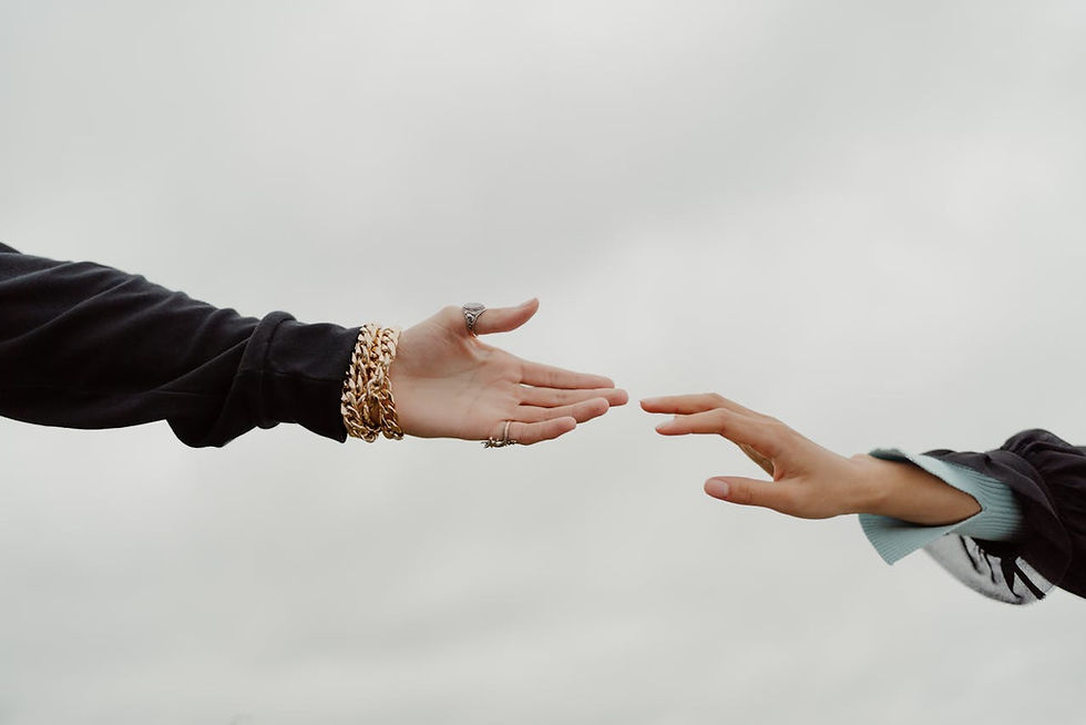 Two hands reaching towards each other against a cloudy sky, indicating trust is improtant to make any relationship work.