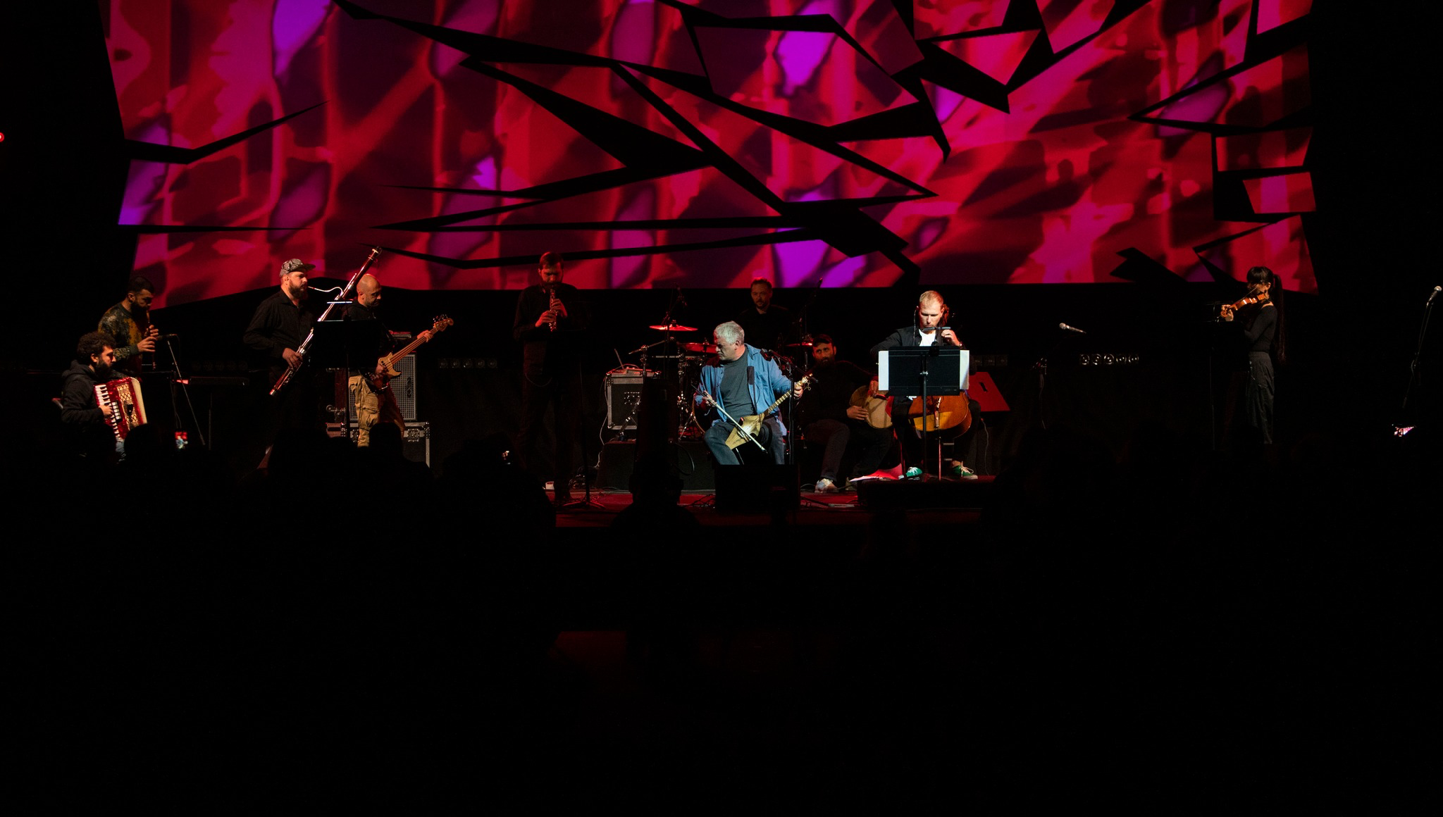 Live performance beneath a red illuminated structure.