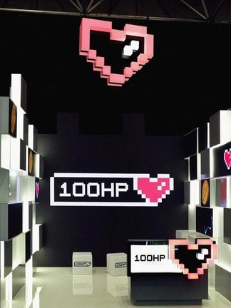 Pixel-inspired 100 HP Gaming stand and suspended heart logo.