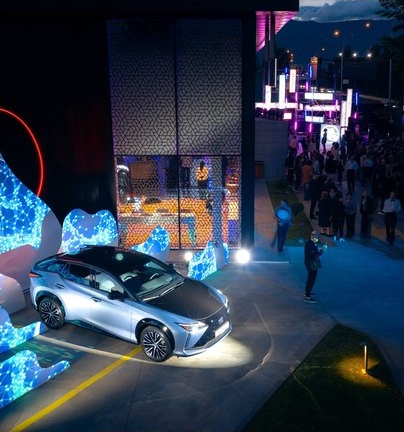 Lexus RZ framed by wave-shaped LED sculptures.