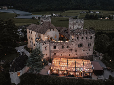 Schloss Freudenstein in Südtirol aus der Vogelperspektive bei Nacht.