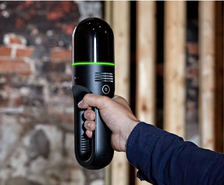 Close-up view of a laser scanning device capturing building measurements