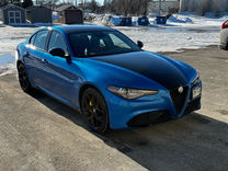 Blue car with a custom wrap design from Mustang Signs and Graphics, parked in a lot.