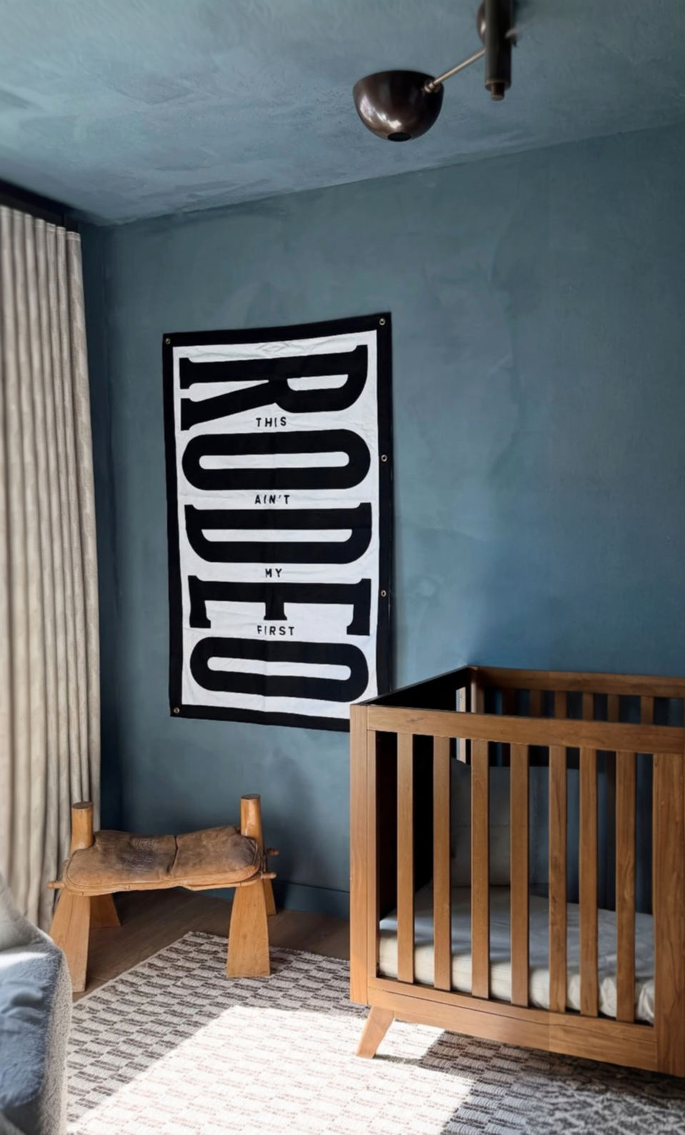 Blue Roman Clay textured walls in modern nursery design with wooden crib. Limewash style accent wall contractor for kids rooms in Camas WA, Felida, and Ridgefield.