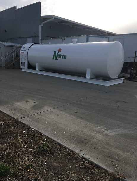 Sideways industrial white tank after coat and paint with Norco Logo