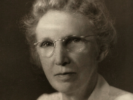 Portrait of an elderly woman in glasses, with text overlay: "After raising seven children, my grandmother took classes at the University."