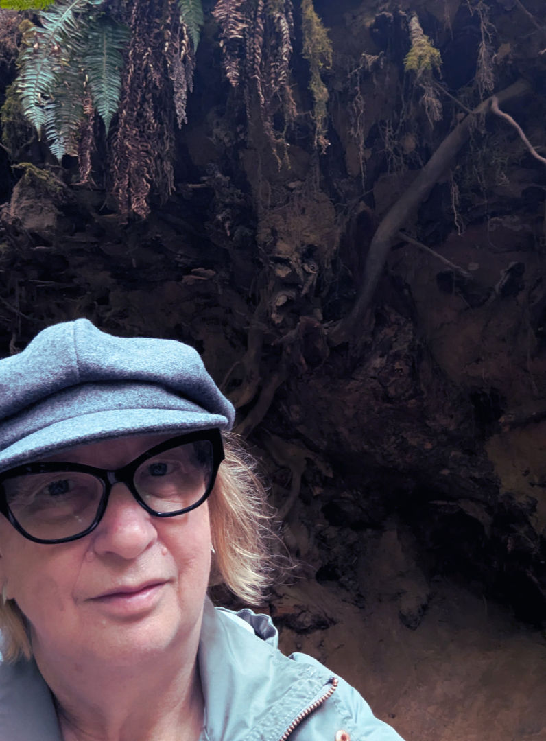 Selfie in front of a huge tree root.