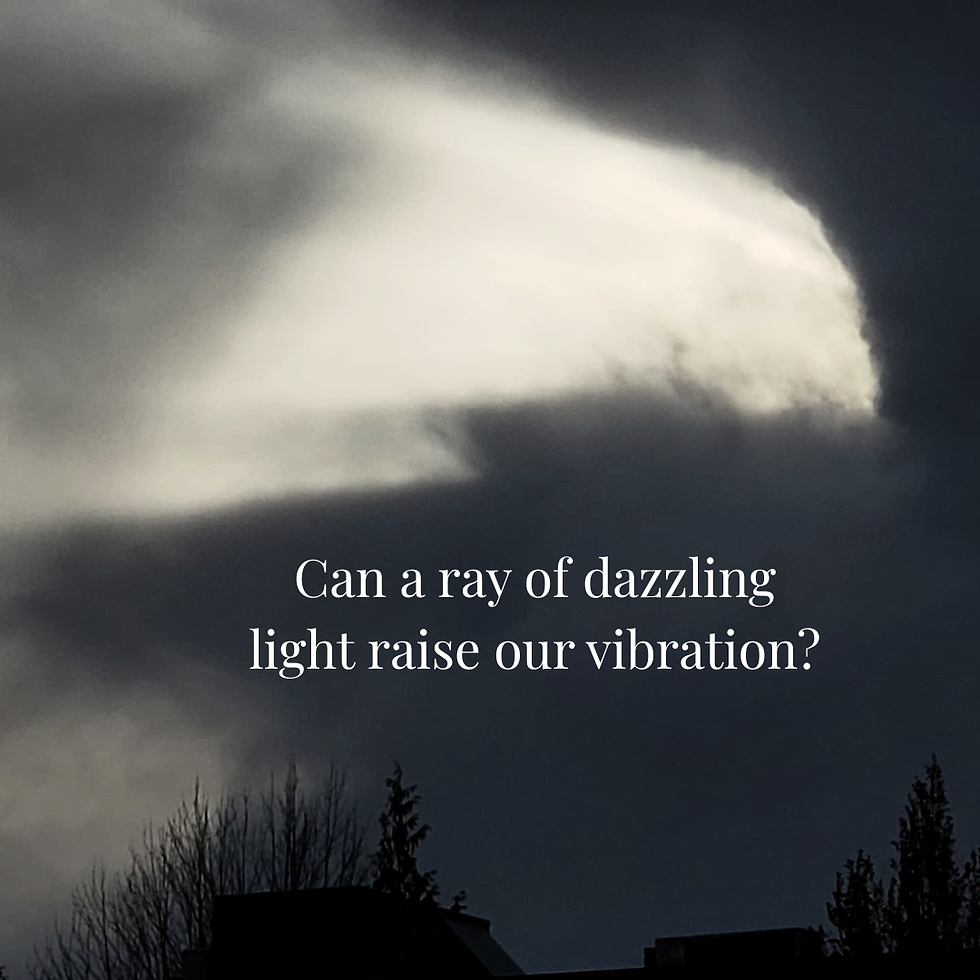 Dark sky with a bright cloud over silhouetted trees and rooftops, overlaid with text: Can a ray of dazzling light raise our vibration?